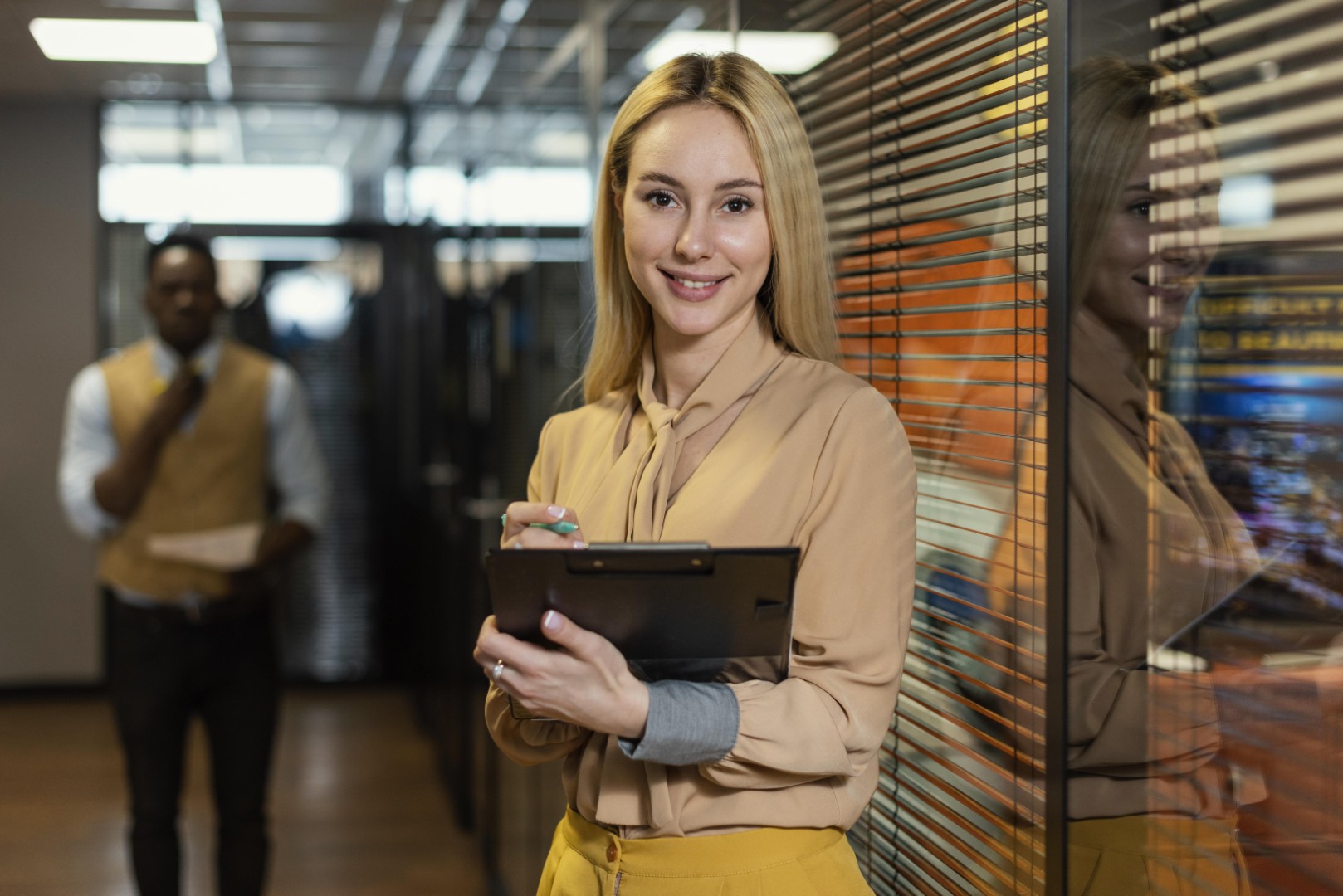 mulher sorridente segurando uma prancheta no local de trabalho Grande